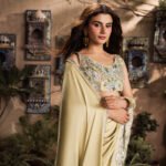 Model wearing Marigold luxury pure Shamooz silk saree with embroidered blouse and handcrafted embellishments.