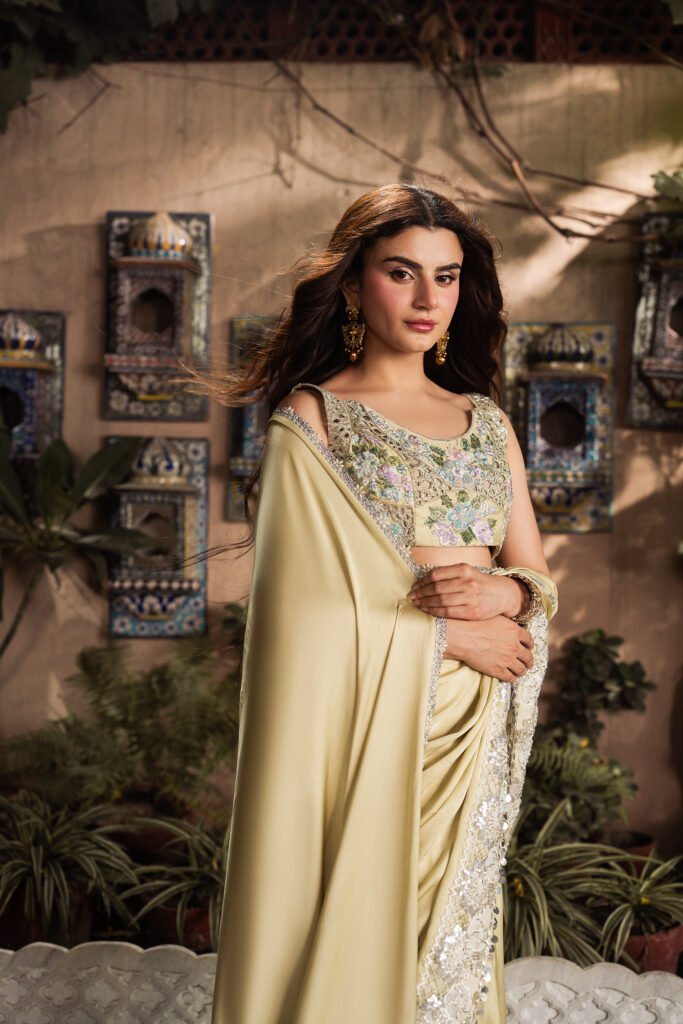 Model wearing Marigold luxury pure Shamooz silk saree with embroidered blouse and handcrafted embellishments.